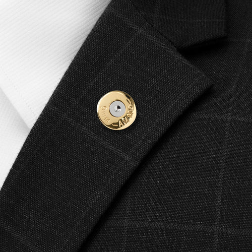 Bullet-shaped lapel pin with round face, mounted on dark suit lapel
