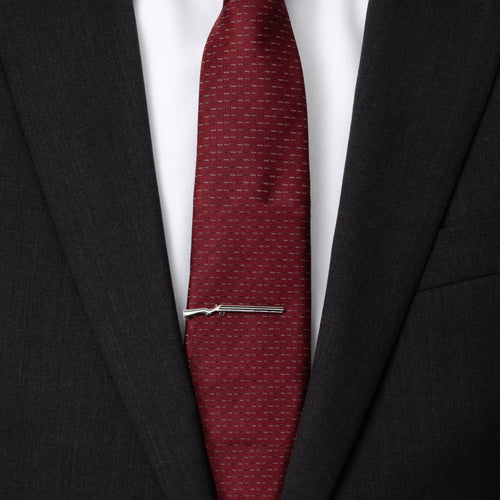 Shotgun tie clip holding a maroon patterned tie between suit lapels