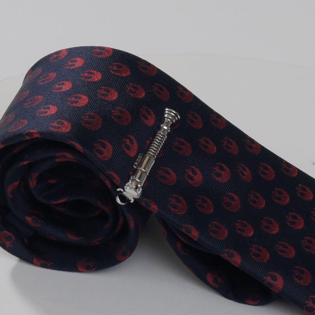 Silver lightsaber-style tie clip on dark patterned necktie