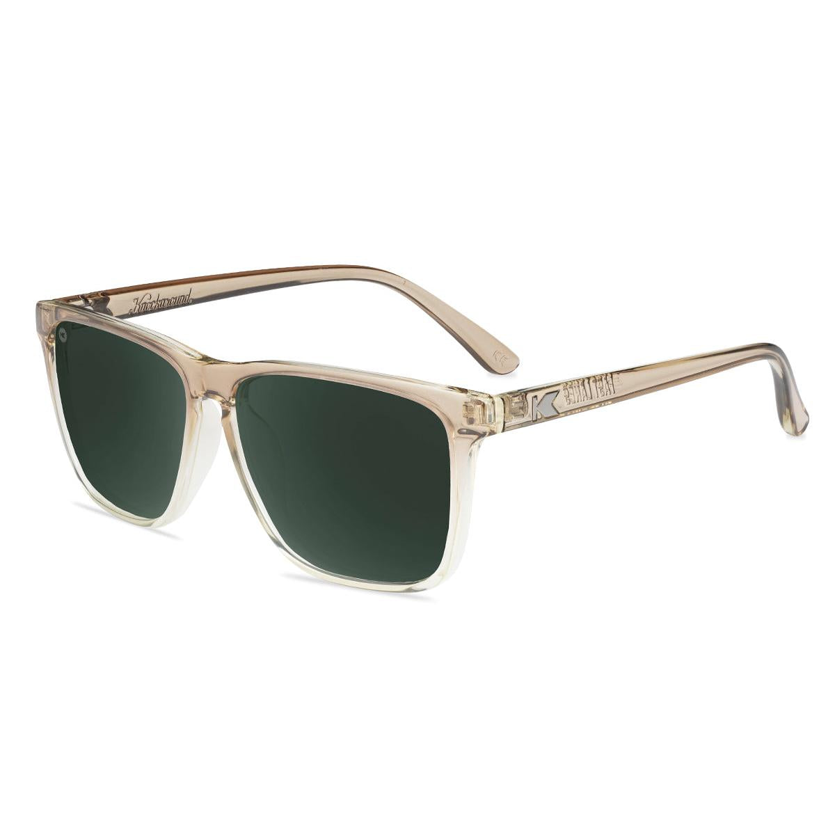 Square sunglasses with clear tan frames and green tinted lenses.
