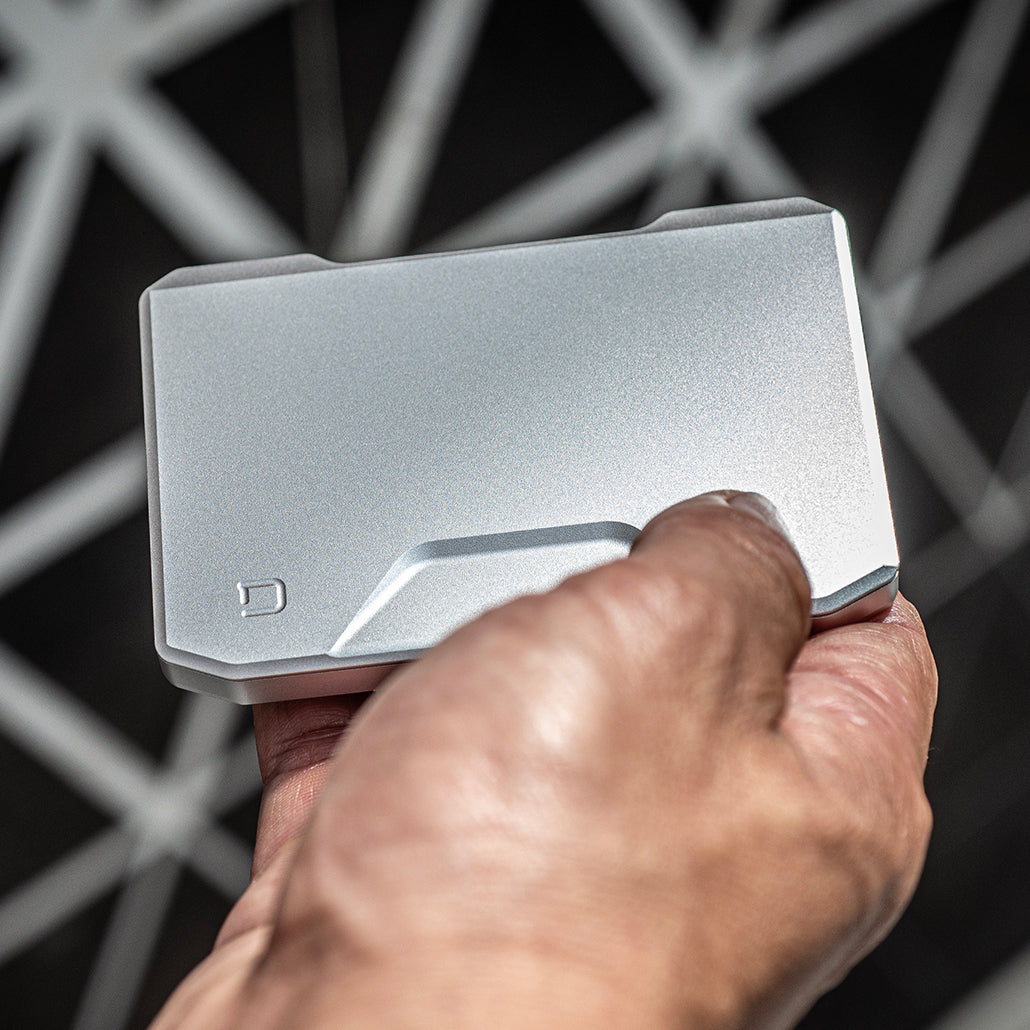 Satin silver slide kick wallet opening with hand pushing card tray