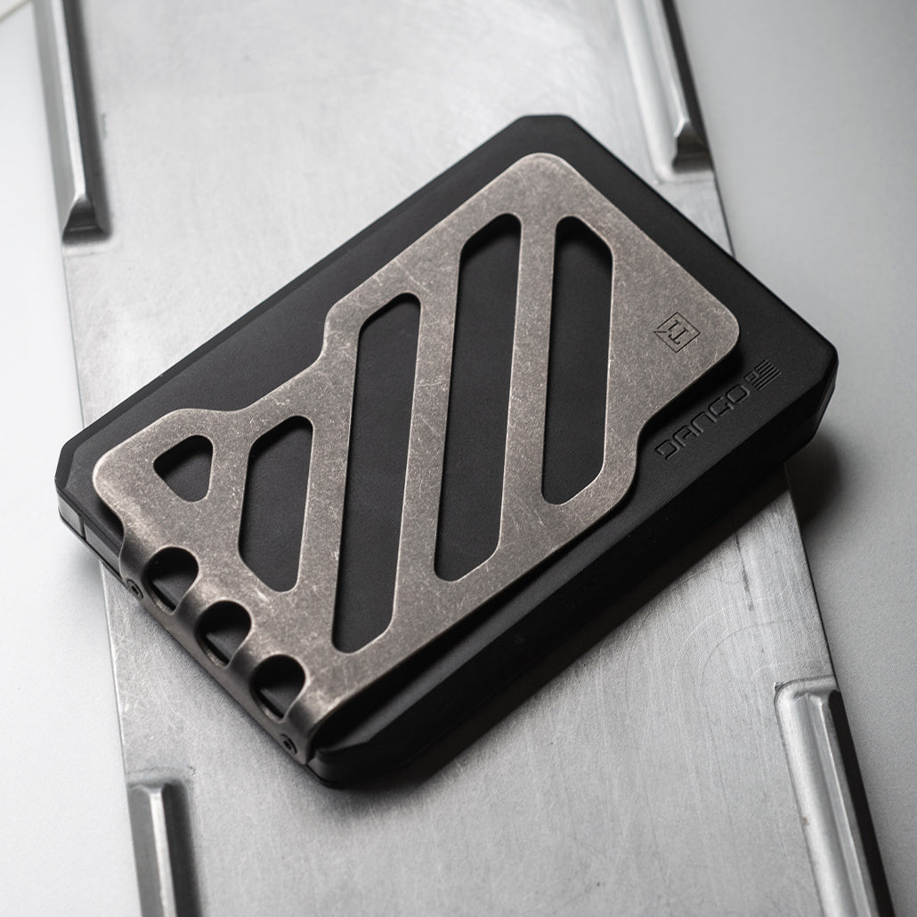 Black slide wallet with metallic titanium money clip on silver tray