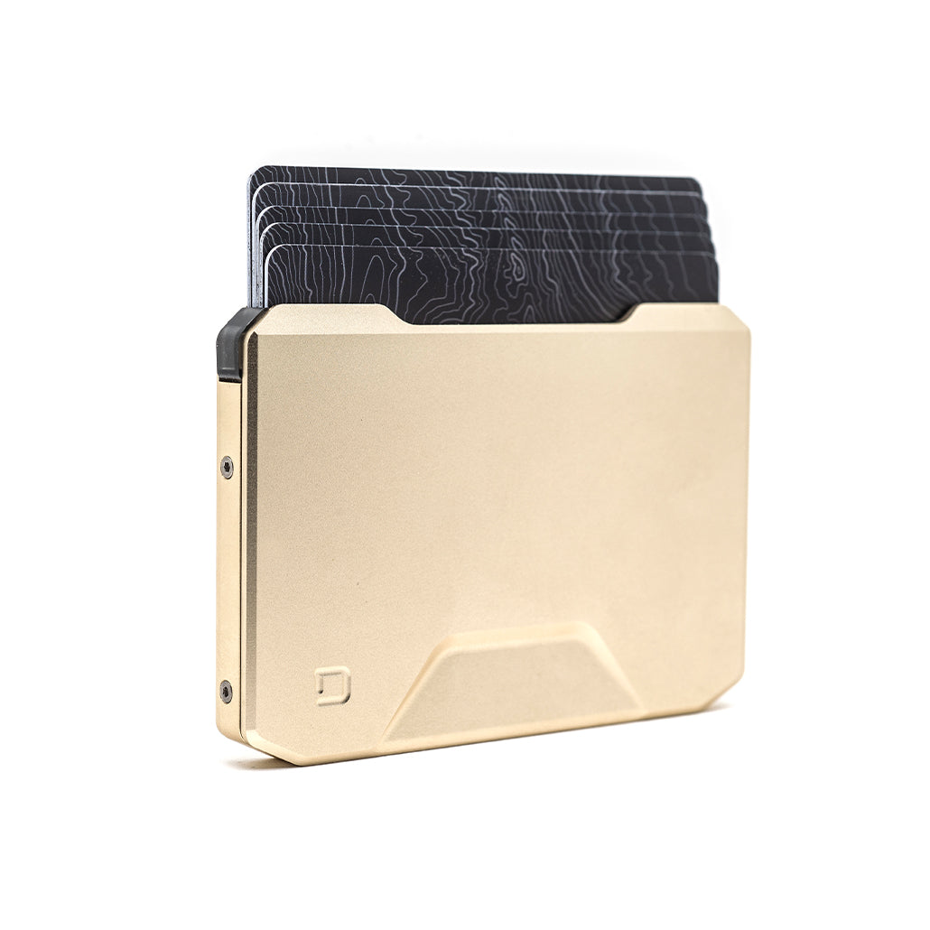 Champagne gold slide kick wallet with black textured card cover behind it